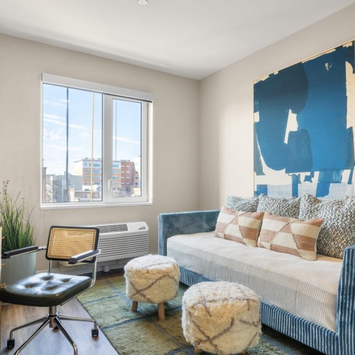 a living room with a large painting and a blue couch