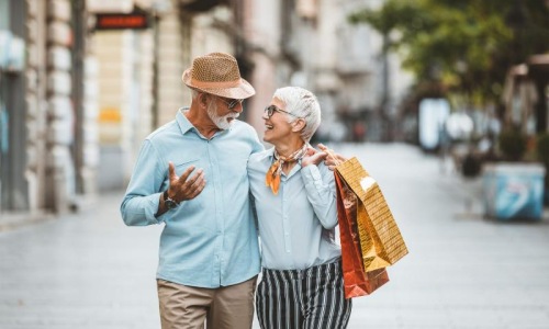 Close to the center of everything a man and woman holding shopping bags while walking