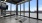 a gym room with large windows and a tv on the wall